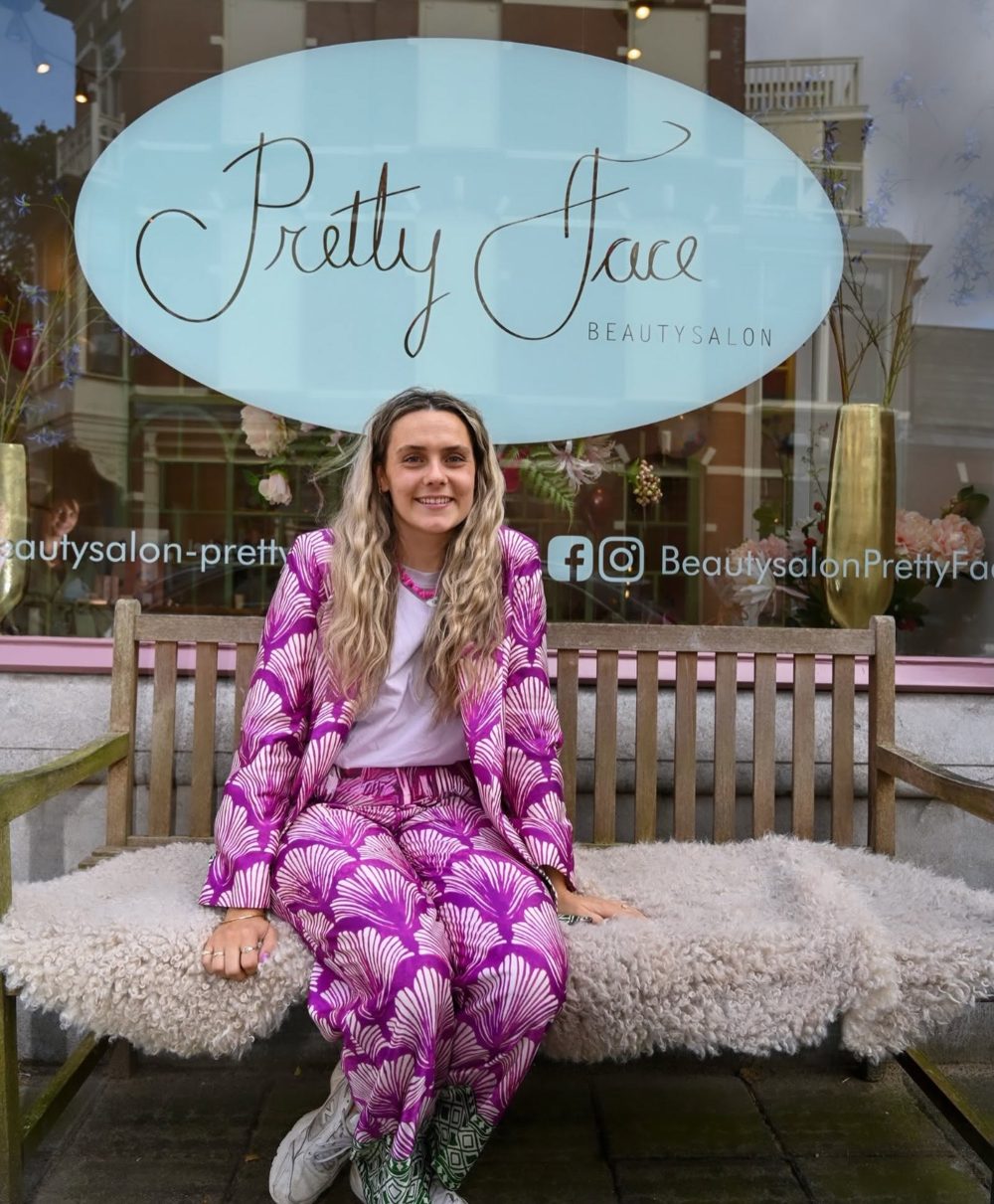 Sanne, oprichter van Pretty Face, op het bankje voor de salon aan de Stevinstraat